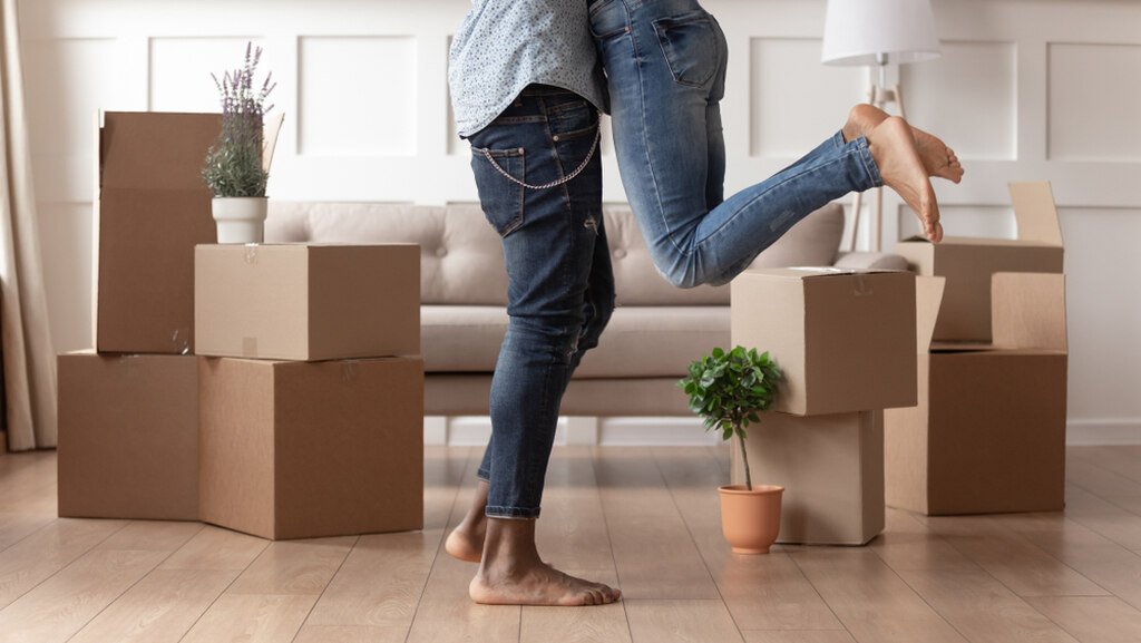 Alugar ou comprar imóvel? Entenda de uma vez por todas 5 casal com caixas de mudança representando se vale mais a pena alugar ou comprar imóvel