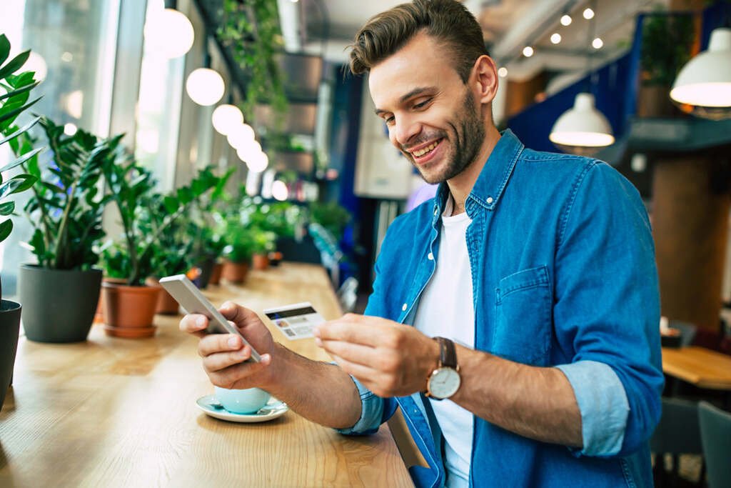 Como antecipar parcela do cartão de crédito? Veja se vale a pena e como fazer 2 homem usando celular para saber como antecipar parcela do cartão de crédito