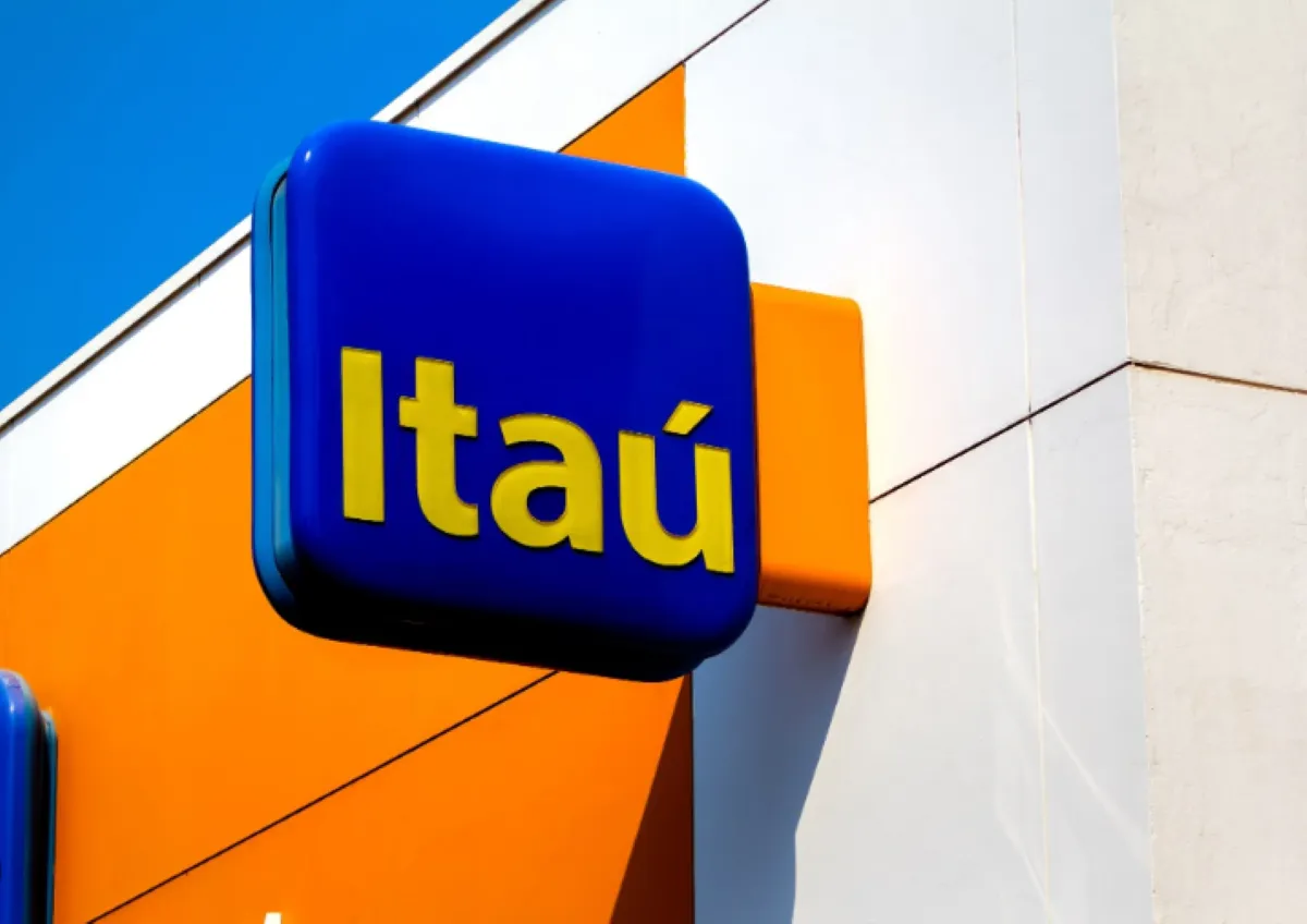 Placa do Banco Itaú em destaque na fachada de prédio.