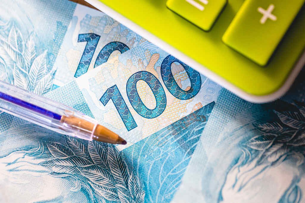 Imposto de Renda MEI 2025: tudo o que você precisa saber! 18 notas de 100 reais representando o Imposto de Renda MEI