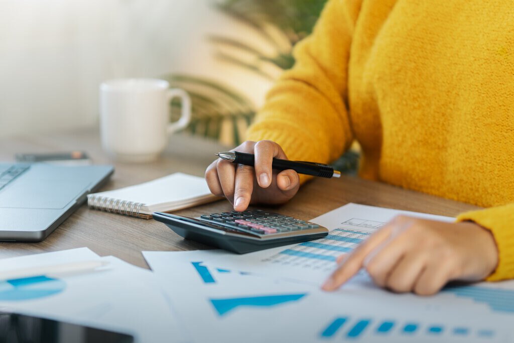 Imposto de Renda MEI 2025: tudo o que você precisa saber! 17 pessoa calculando valor do Imposto de Renda MEI