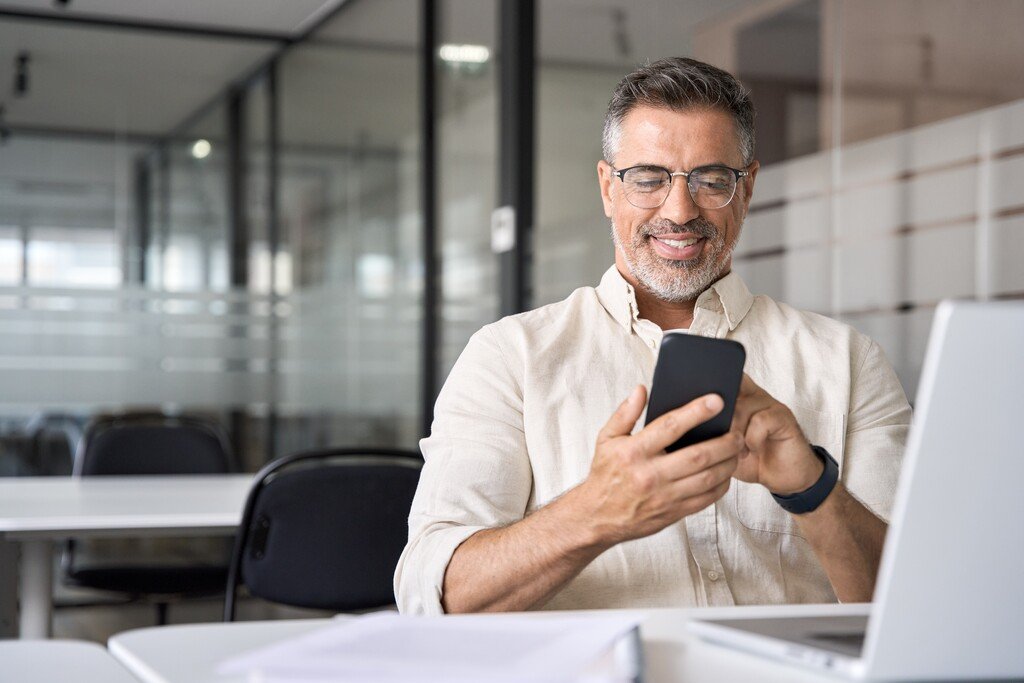 Qual o melhor banco para antecipar FGTS? Tire suas dúvidas! 31 homem pesquisando no celular qual é o melhor banco para antecipar FGTS