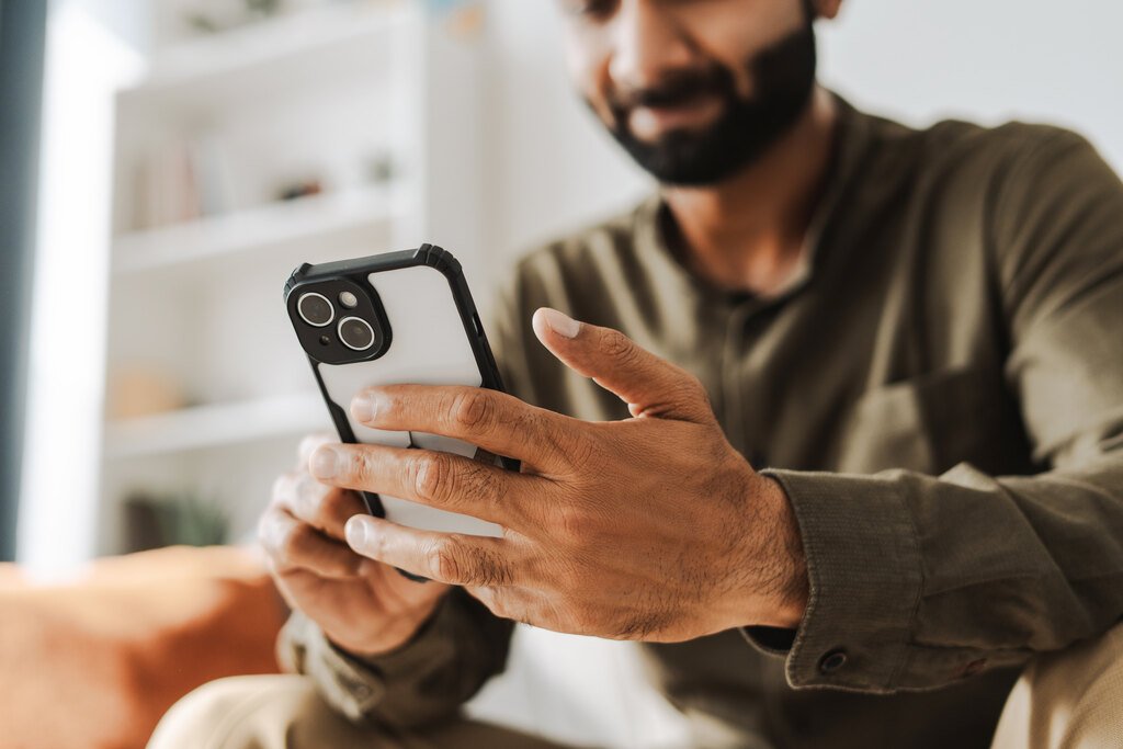 Qual o melhor banco para antecipar FGTS? Tire suas dúvidas! 32 homem pesquisando no celular sobre o melhor banco para antecipar FGTS