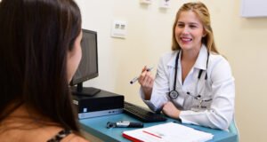 Estudante de Medicina da Unoeste em atendimento simulado com paciente, usando jaleco e estetoscópio, durante atividade prática em consultório-escola.